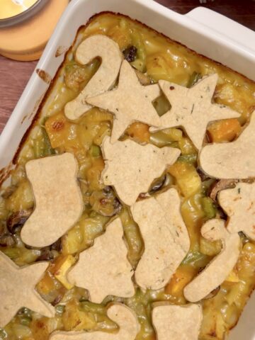 Christmas vegetable pie with rosemary pastry cut-outs baked until golden, filled with potatoes, butternut squash, mushrooms, and green beans.