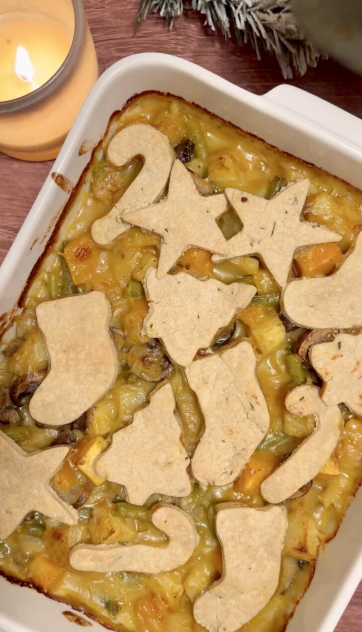 Christmas vegetable pie with rosemary pastry cut-outs baked until golden, filled with potatoes, butternut squash, mushrooms, and green beans.