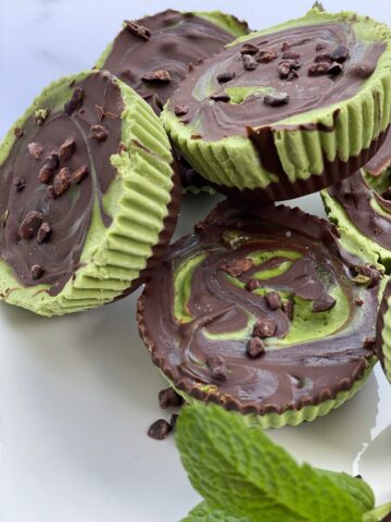 Healthy vegan grasshopper cups with mint chocolate swirl filling, dairy-free and naturally sweetened, topped with cacao nibs for a St. Patrick’s Day dessert.