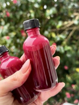 Beet ginger juice shots in clear glass bottles, rich in nitrates and antioxidants for athletic performance.