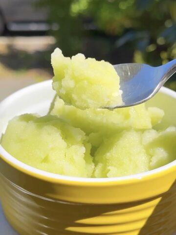 Ginger honeydew melon sorbet in a yellow bowl with spoon, a refreshing healthy green St. Patrick’s Day dessert.