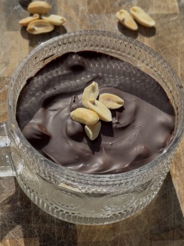 High-protein Snickers crack bowl made with Greek yogurt, peanut butter powder, date caramel, salted peanuts, and a dark chocolate shell.