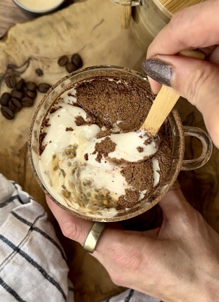 High-protein tiramisu overnight oats topped with creamy tofu and cottage cheese layer and cocoa powder, served in a glass mug with espresso and oats for a healthy performance-nutrition breakfast.