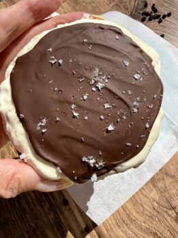 High-protein frozen rice cake s’mores topped with melted chocolate and flaky sea salt, made with coconut whipped topping and protein powder for a healthy dessert option.