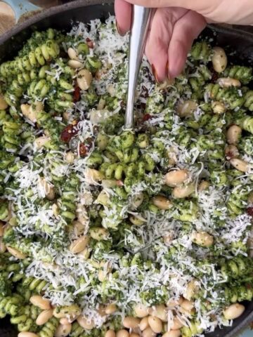 Creamy kale pesto pasta made with rotini pasta, white beans, sun-dried tomatoes, parmesan cheese, and fresh kale pesto topped with extra parmesan. Quick and nourishing vegetarian pasta recipe perfect for healthy weeknight dinners, meal prep, and cozy comfort food meals.