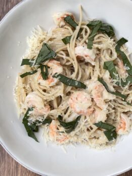 Creamy shrimp pasta made with spaghetti noodles, parmesan cheese, fresh basil, and sautéed shrimp served in a white bowl. Cozy Italian-inspired seafood pasta recipe perfect for weeknight dinners, date nights, and comforting homemade meals.