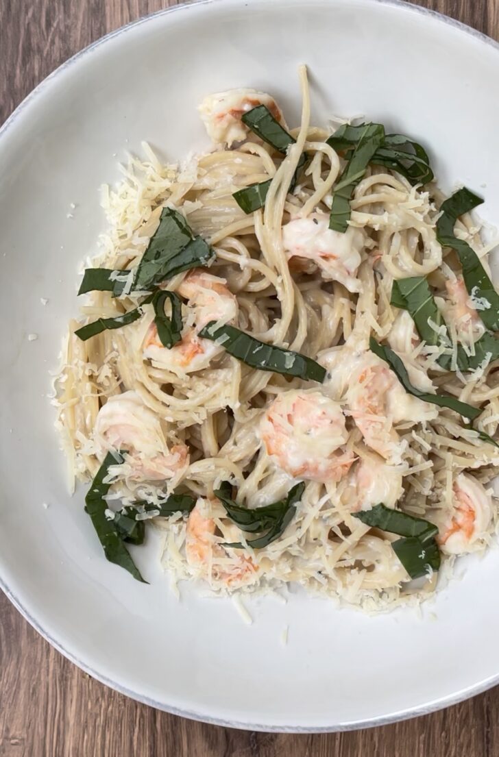 Creamy shrimp pasta made with spaghetti noodles, parmesan cheese, fresh basil, and sautéed shrimp served in a white bowl. Cozy Italian-inspired seafood pasta recipe perfect for weeknight dinners, date nights, and comforting homemade meals.