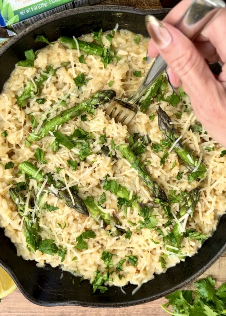 Creamy asparagus and lemon risotto made with arborio rice, fresh asparagus, parmesan cheese, herbs, and lemon in a black skillet. Cozy spring-inspired comfort food recipe with a rich creamy texture perfect for weeknight dinners and elegant homemade meals.